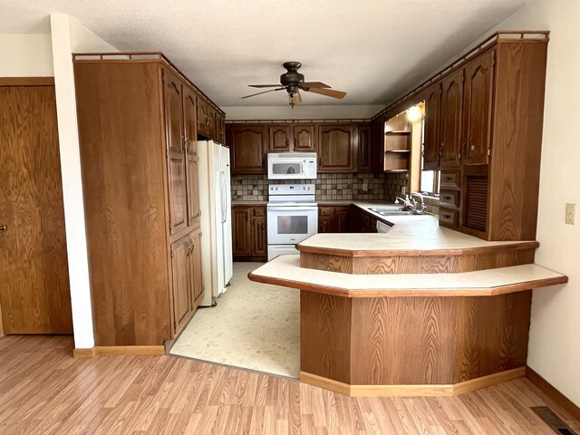 310 8th St, Windom, MN 56101 - kitchen featuring white appliances, ceiling fan, a peninsula, light wood finished floors, and light countertops