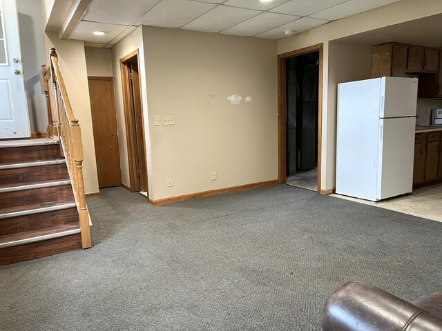 310 8th St, Windom, MN 56101 - unfurnished living room with light carpet, stairs, baseboards, and a drop ceiling