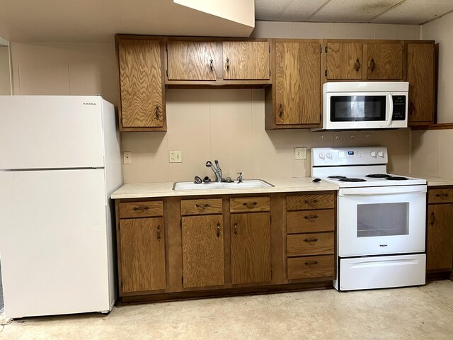 310 8th St, Windom, MN 56101 - kitchen featuring white appliances, a sink, light countertops, brown cabinetry, and light floors