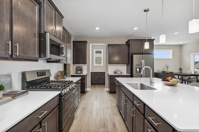 7657 Swan St, Lino Lakes, MN 55038 - kitchen featuring stainless steel appliances, a sink, light wood-type flooring, dark brown cabinets, and recessed lighting