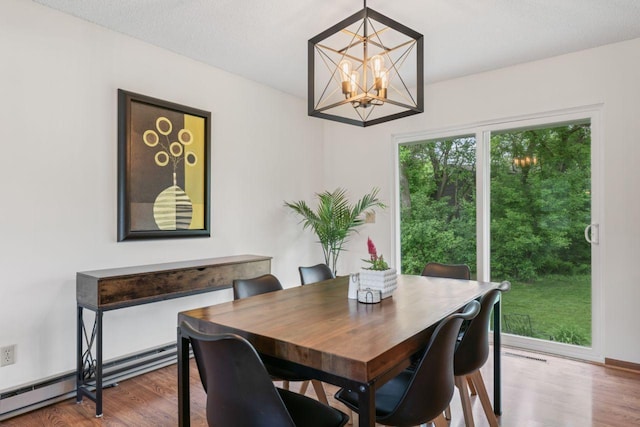 1719 Buckingham Path, Faribault, MN 55021 - dining area featuring a chandelier, wood finished floors, and a baseboard heating unit