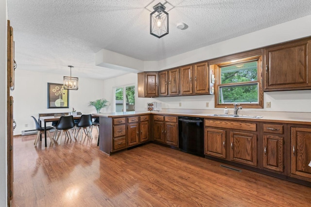 1719 Buckingham Path, Faribault, MN 55021 - kitchen with dishwasher, a sink, wood finished floors, a textured ceiling, and a peninsula