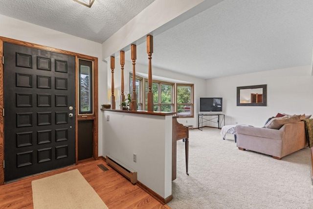 1719 Buckingham Path, Faribault, MN 55021 - entryway featuring a baseboard heating unit, a textured ceiling, light wood-style flooring, and baseboards
