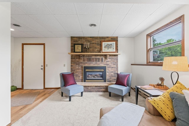1719 Buckingham Path, Faribault, MN 55021 - living area featuring a brick fireplace and wood finished floors