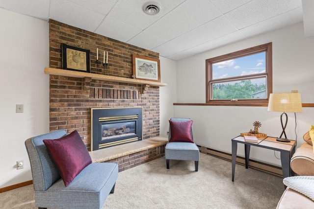 1719 Buckingham Path, Faribault, MN 55021 - carpeted living room featuring baseboard heating, a fireplace, baseboards, and a drop ceiling