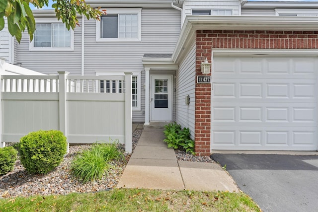 11427 Elmwood Ave N, Champlin, MN 55316 - doorway to property featuring brick siding and a garage
