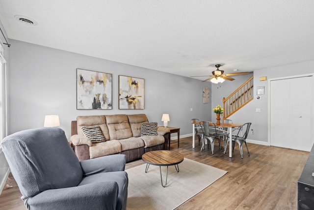 11427 Elmwood Ave N, Champlin, MN 55316 - living area featuring stairway, ceiling fan, and wood finished floors