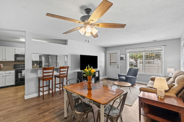 11427 Elmwood Ave N, Champlin, MN 55316 - dining space with a textured ceiling, ceiling fan, and wood finished floors