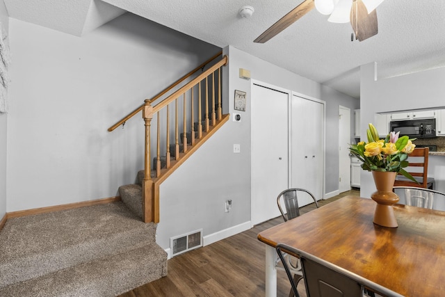 11427 Elmwood Ave N, Champlin, MN 55316 - dining area featuring stairs, dark wood-style floors, a ceiling fan, and a textured ceiling