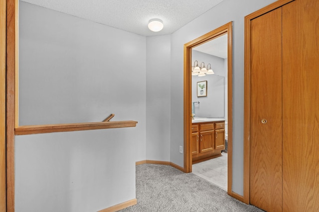 11427 Elmwood Ave N, Champlin, MN 55316 - hallway featuring light carpet, a textured ceiling, and an upstairs landing