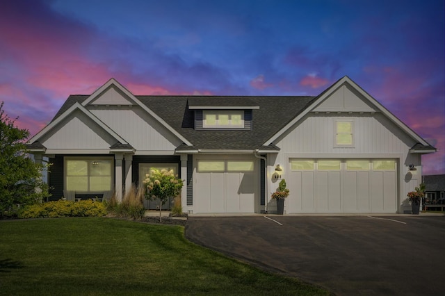 584 Reynolds St, River Falls, WI 54022 - view of front facade featuring driveway, a shingled roof, a front lawn, and a garage