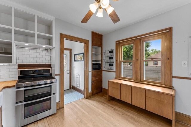 4129 7th St NE, Columbia Heights, MN 55421 - kitchen with range with two ovens, black microwave, light wood-style floors, a ceiling fan, and open shelves