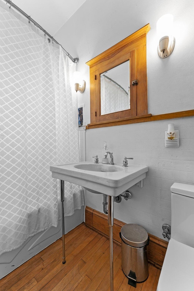 4129 7th St NE, Columbia Heights, MN 55421 - bathroom with wood-type flooring and curtained shower