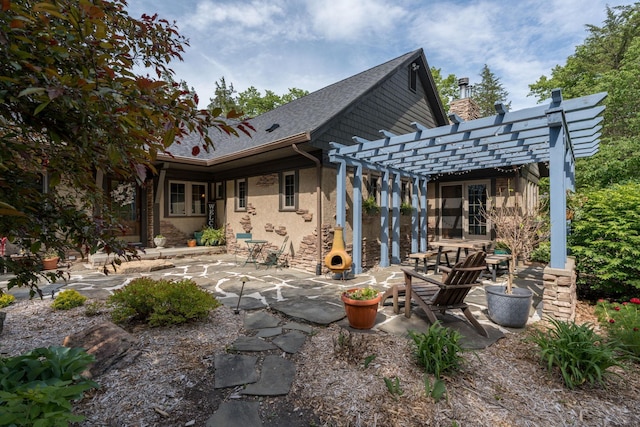 56273 185th Ln, Rapidan Twp, MN 56037 - back of property with a pergola, a patio area, stucco siding, and a shingled roof