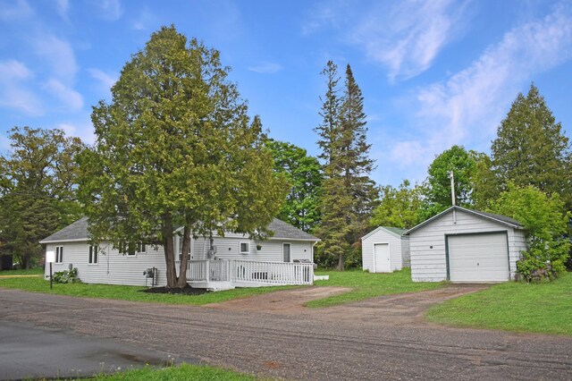 630 Oak St, Crosby, MN 56441 - view of front of property featuring an outdoor structure, a detached garage, dirt driveway, and a front lawn