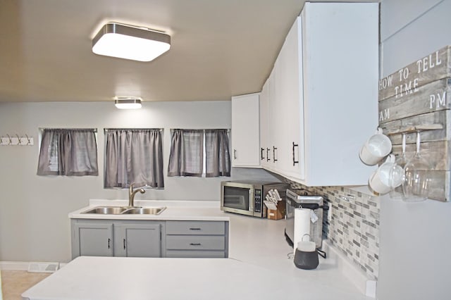 630 Oak St, Crosby, MN 56441 - kitchen with stainless steel microwave, a sink, gray cabinetry, tasteful backsplash, and light countertops