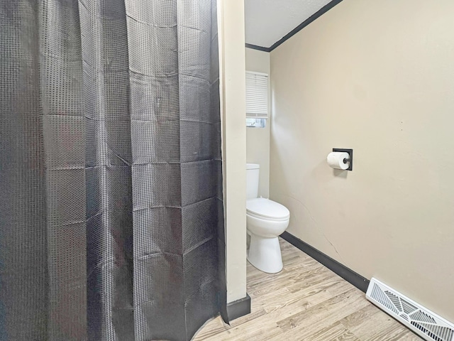630 Oak St, Crosby, MN 56441 - bathroom with wood finished floors, toilet, baseboards, and a shower with curtain