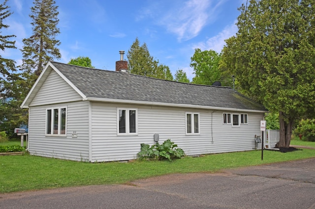 630 Oak St, Crosby, MN 56441 - view of home's exterior with a chimney, roof with shingles, and a yard