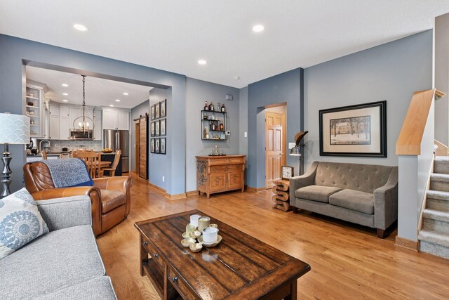 2392 Molnau Ct, Chaska, MN 55318 - living room with stairway, a chandelier, light wood-style floors, recessed lighting, and baseboards