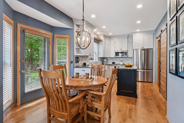 2392 Molnau Ct, Chaska, MN 55318 - dining space with a chandelier, light wood-type flooring, recessed lighting, baseboards, and a barn door