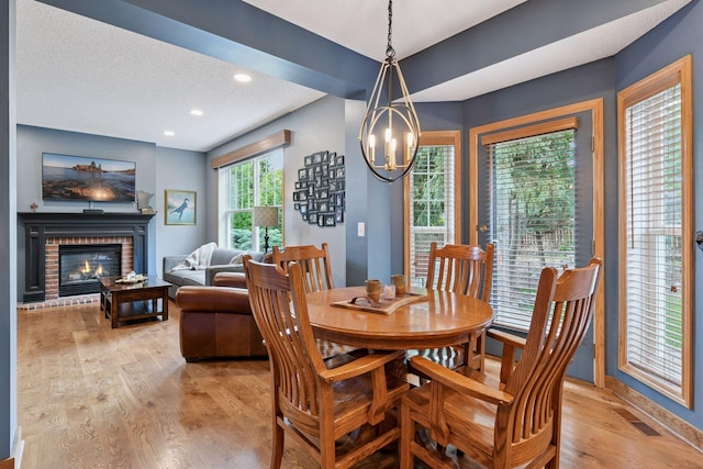 2392 Molnau Ct, Chaska, MN 55318 - dining space featuring light wood-style floors, a chandelier, baseboards, a brick fireplace, and recessed lighting