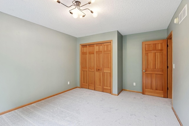 2392 Molnau Ct, Chaska, MN 55318 - unfurnished bedroom featuring a closet, carpet flooring, a textured ceiling, baseboards, and a chandelier