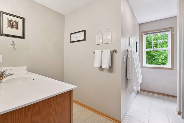 2392 Molnau Ct, Chaska, MN 55318 - bathroom with a textured ceiling, vanity, baseboards, and tile patterned flooring