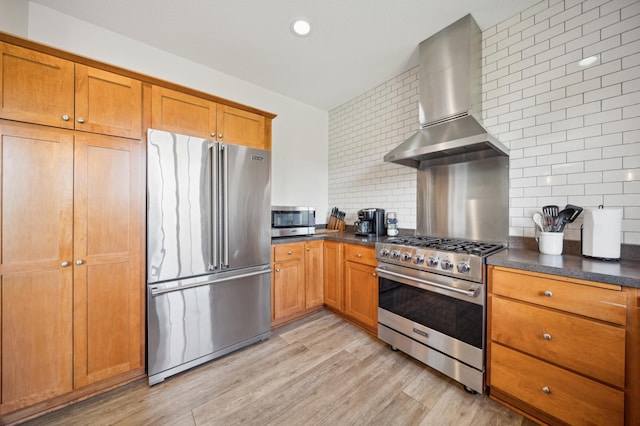 1106 Shumway Ct, Faribault, MN 55021 - kitchen featuring high end appliances, island exhaust hood, backsplash, dark countertops, and light wood-style floors