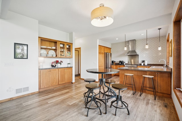 1106 Shumway Ct, Faribault, MN 55021 - kitchen featuring wall chimney exhaust hood, light wood-type flooring, and a sink