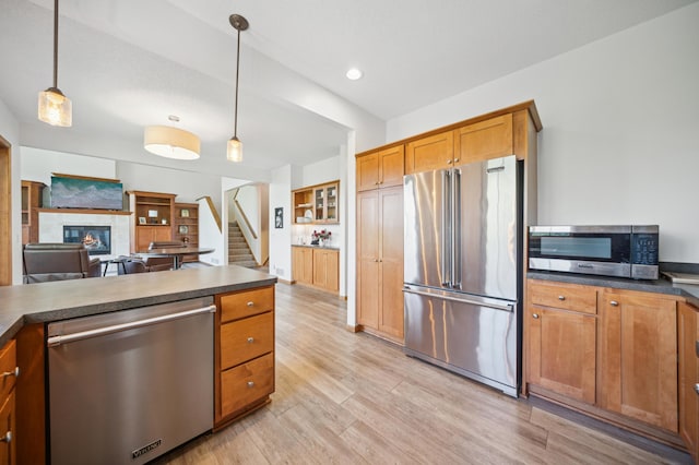 1106 Shumway Ct, Faribault, MN 55021 - kitchen with appliances with stainless steel finishes, brown cabinetry, dark countertops, light wood-style flooring, and recessed lighting