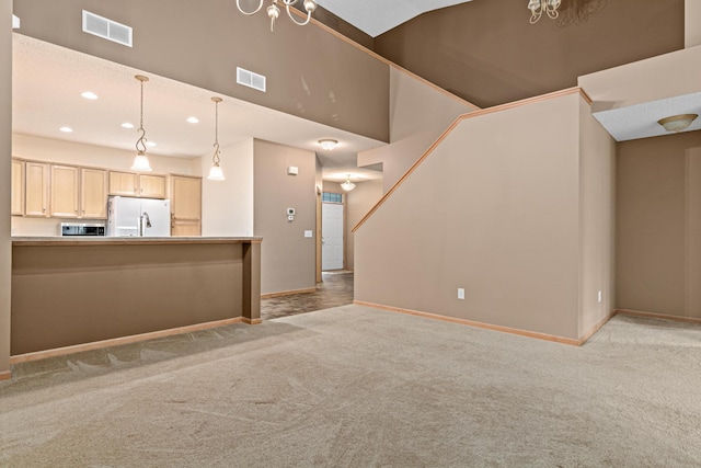 15440 Eminence Ave N Unit 2, Hugo, MN 55038 - unfurnished living room featuring light colored carpet, baseboards, recessed lighting, stairs, and a towering ceiling