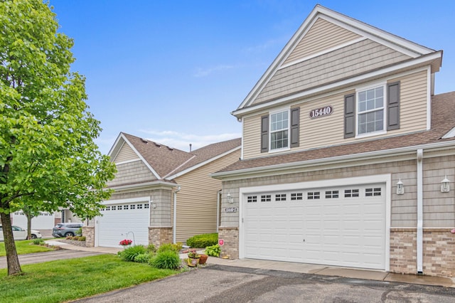 15440 Eminence Ave N Unit 2, Hugo, MN 55038 - view of front of home featuring brick siding, asphalt driveway, an attached garage, and roof with shingles