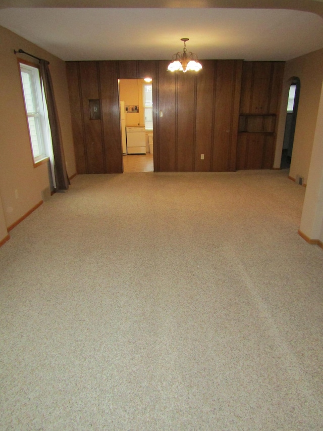 421 8th Ave, Madison, MN 56256 - spare room featuring a chandelier, carpet, baseboards, and arched walkways