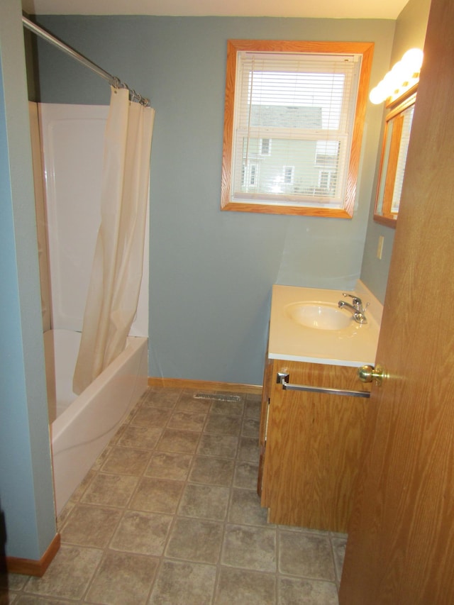 421 8th Ave, Madison, MN 56256 - full bathroom with baseboards, vanity, and shower / tub combo with curtain