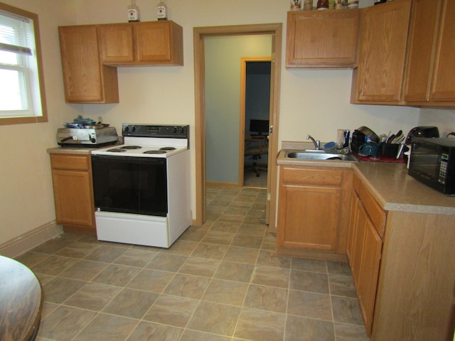 421 8th Ave, Madison, MN 56256 - kitchen featuring white electric range, a sink, black microwave, light countertops, and baseboards