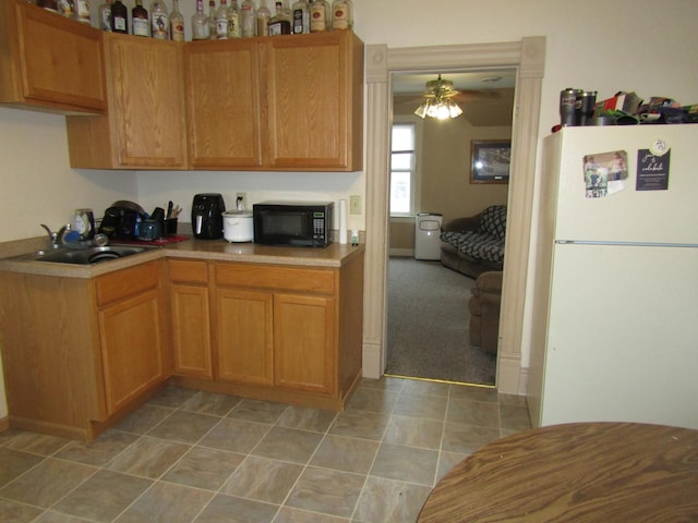 421 8th Ave, Madison, MN 56256 - kitchen featuring freestanding refrigerator, black microwave, light countertops, and a sink