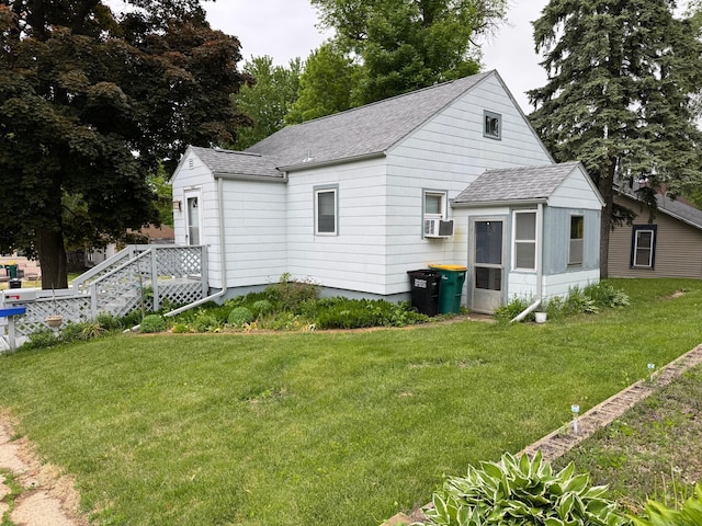1020 Autumn St, Albert Lea, MN 56007 - view of front of property featuring roof with shingles, a front yard, cooling unit, and a sunroom