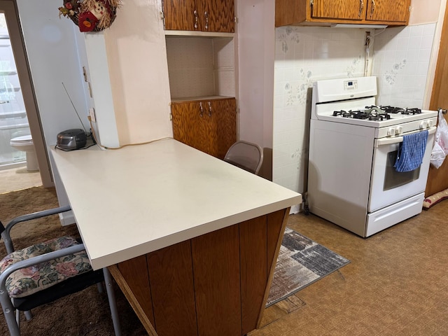 1020 Autumn St, Albert Lea, MN 56007 - kitchen with white range with gas stovetop, light countertops, a breakfast bar area, and a peninsula