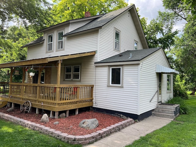 355 20th St SW, Benson, MN 56215 - back of house with a chimney, a shingled roof, and a lawn