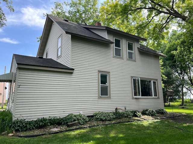 355 20th St SW, Benson, MN 56215 - view of home's exterior with a lawn, a chimney, and roof with shingles
