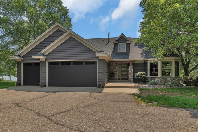27806 Sundance Ln, Cold Spring, MN 56320 - view of front of home with driveway, a garage, stone siding, and a shingled roof