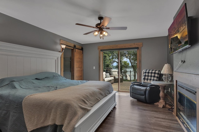 27806 Sundance Ln, Cold Spring, MN 56320 - bedroom featuring access to exterior, wood finished floors, a barn door, a fireplace, and a ceiling fan