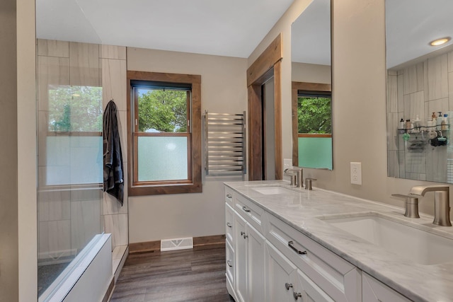 27806 Sundance Ln, Cold Spring, MN 56320 - full bathroom featuring double vanity, wood finished floors, and a towel warming rack