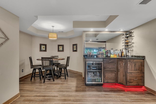 27806 Sundance Ln, Cold Spring, MN 56320 - indoor dry bar with wine cooler, wood finished floors, recessed lighting, pendant lighting, and a tray ceiling