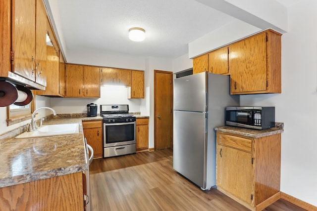 1202 Lyn Way, Hastings, MN 55033 - kitchen with stainless steel appliances, a sink, brown cabinets, and wood finished floors