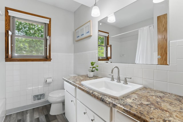 1202 Lyn Way, Hastings, MN 55033 - bathroom featuring tile walls, vanity, toilet, a shower with curtain, and wood finished floors