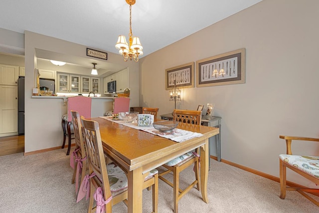 15610 24th Ave N Unit F, Plymouth, MN 55447 - dining space with light colored carpet, a chandelier, and baseboards