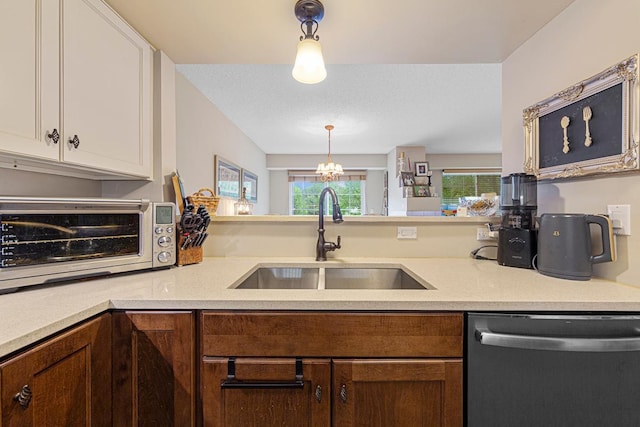 15610 24th Ave N Unit F, Plymouth, MN 55447 - kitchen with stainless steel dishwasher, a sink, light countertops, white cabinetry, and decorative light fixtures