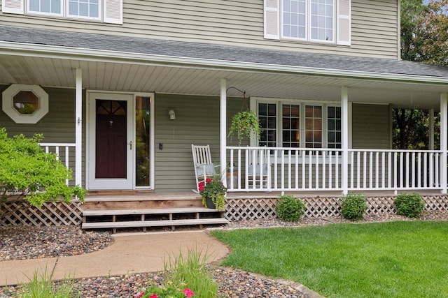 1502 Rocky Ln, Eagan, MN 55122 - view of exterior entry with covered porch, roof with shingles, and a lawn