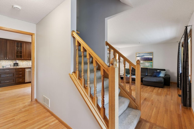 1502 Rocky Ln, Eagan, MN 55122 - stairway with wood finished floors and a textured ceiling